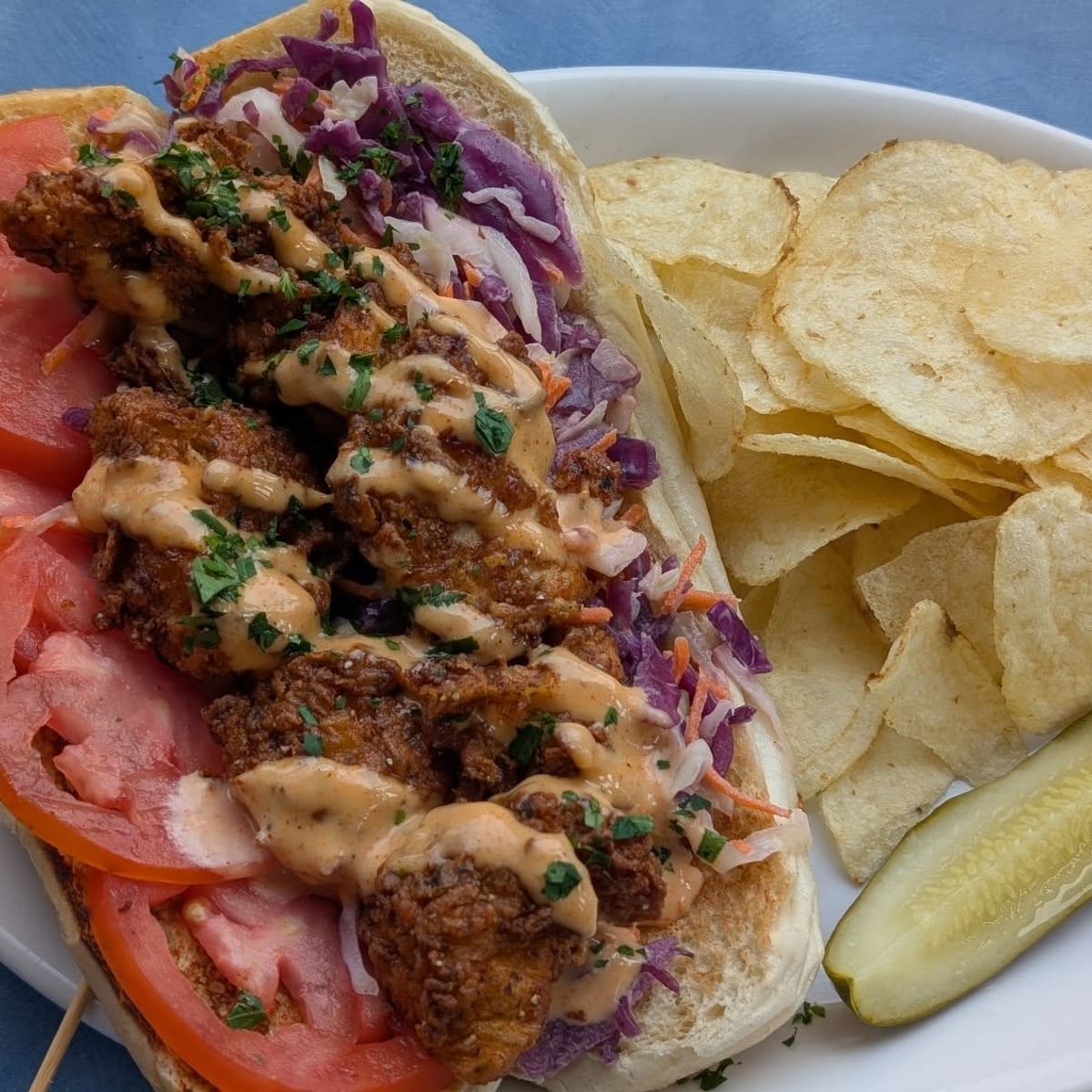 Buttermilk Cajun fried chicken po'boy with slaw, chips and a pickle